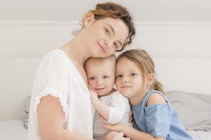 front view mother posing with children, one baby and one toddler, both two under two